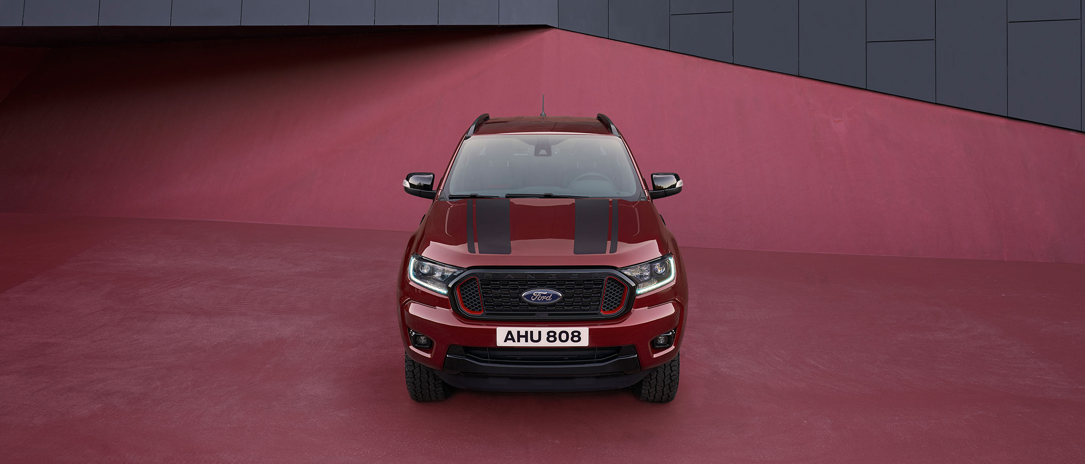 Ford Ranger Stormtrak rot Frontansicht parkt auf rotem Untergrund Ford Ranger Stormtrak rot Frontansicht parkt auf rotem Untergrund