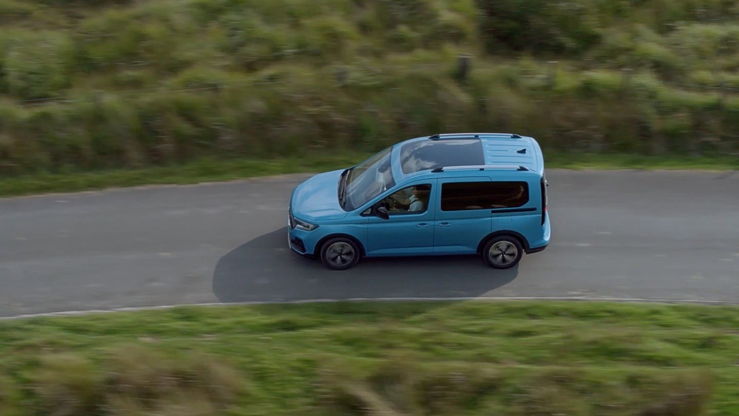 Ford Tourneo Connect in Hellblau Seitenansicht in der Vogelperspektive fährt auf Landstrasse