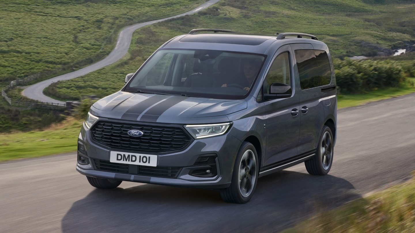 Ford Tourneo Connect in Grau ¾-Frontansicht fährt auf gebirgiger Landstrasse mit Fluss im Hintergrund