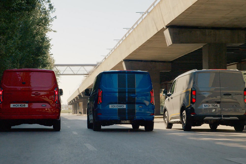 Drei Ford Transit Custom Kleintransporter fahren auf der Autobahn