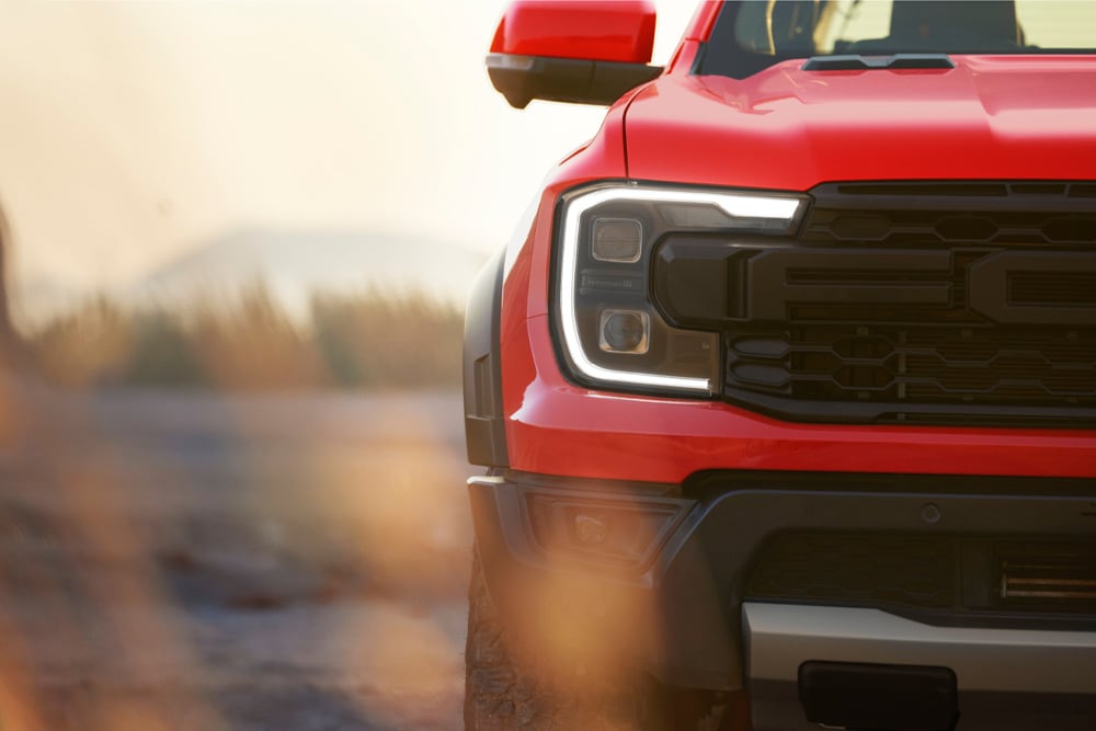 Nahaufnahme des Frontgitters eines roten Ford Ranger Raptors.