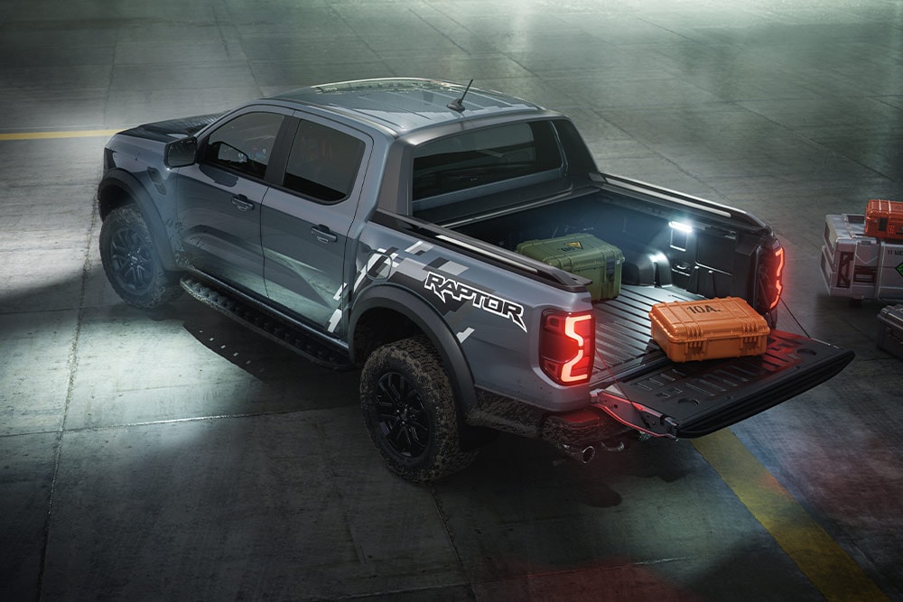 Hinteransicht eines Ford Ranger Raptors, wobei die Aussenbeleuchtung des Fahrzeugs in Szene gesetzt wird.