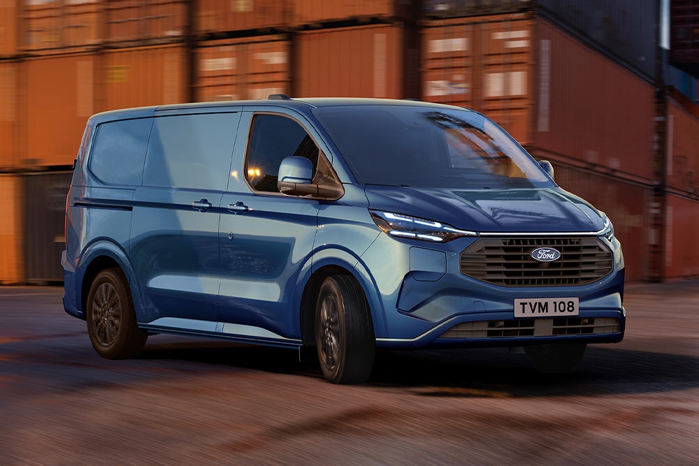 Zusteller lädt Pakete aus einem roten Ford Transit Custom aus. 
