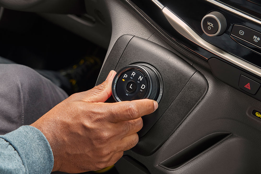 Nahaufnahme einer Hand, die den Gangwahlknopf in einem Ford  E-Transit Elektro-Van dreht.