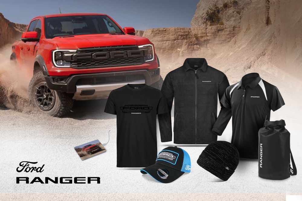 Ford Ranger Kollektion mit schwarzem T-Shirt, Jacke, Polo, Kappe, Mütze und Wetpack, mit einem roten Ranger im Hintergrund. 