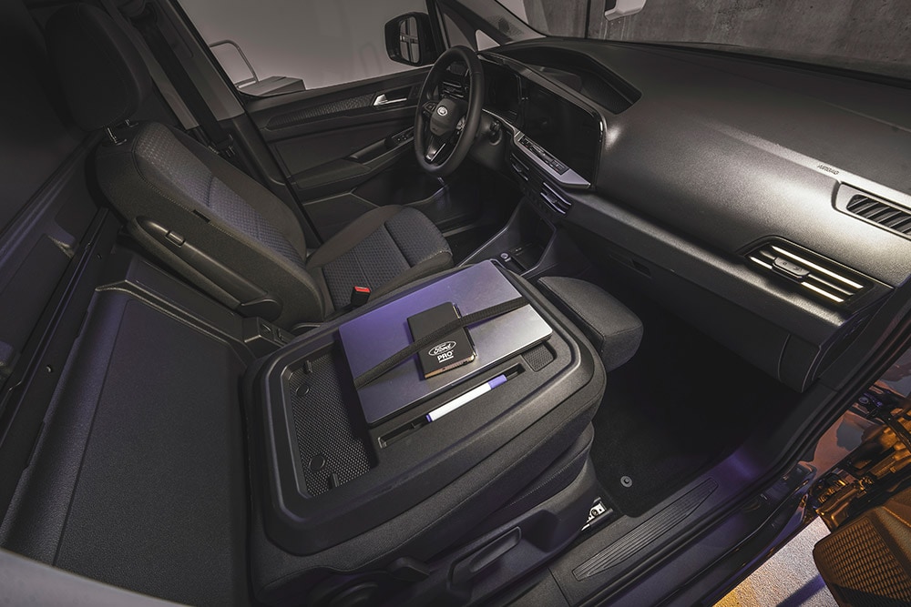Innenraum des Ford Transit Connect mit Armaturenbrett, Sitzen, einem Laptop und einem Telefon auf der Mittelkonsole.
