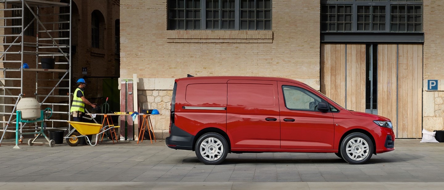 Ford Transit Connect® in Maple Red mit seitlicher Beladetür auf einer Baustelle.