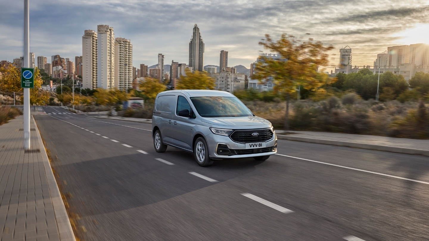 Ford Transit Connect in Stardust Silver fährt auf einer Strasse.