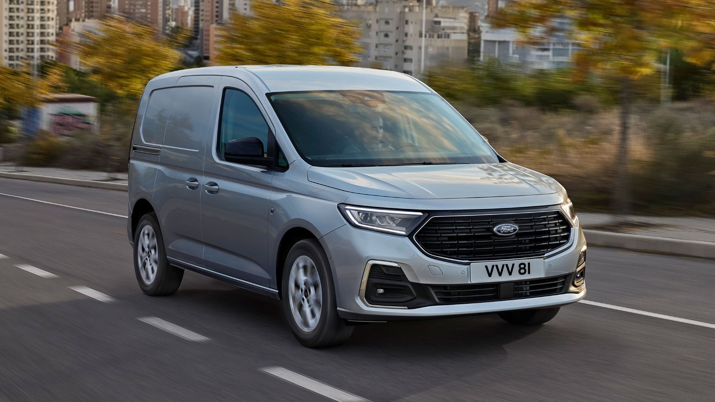 Ford Transit Connect Limited in Stardust Silver mit Chrom-Zierleisten und automatischen Scheinwerfern fährt auf einer Strasse.