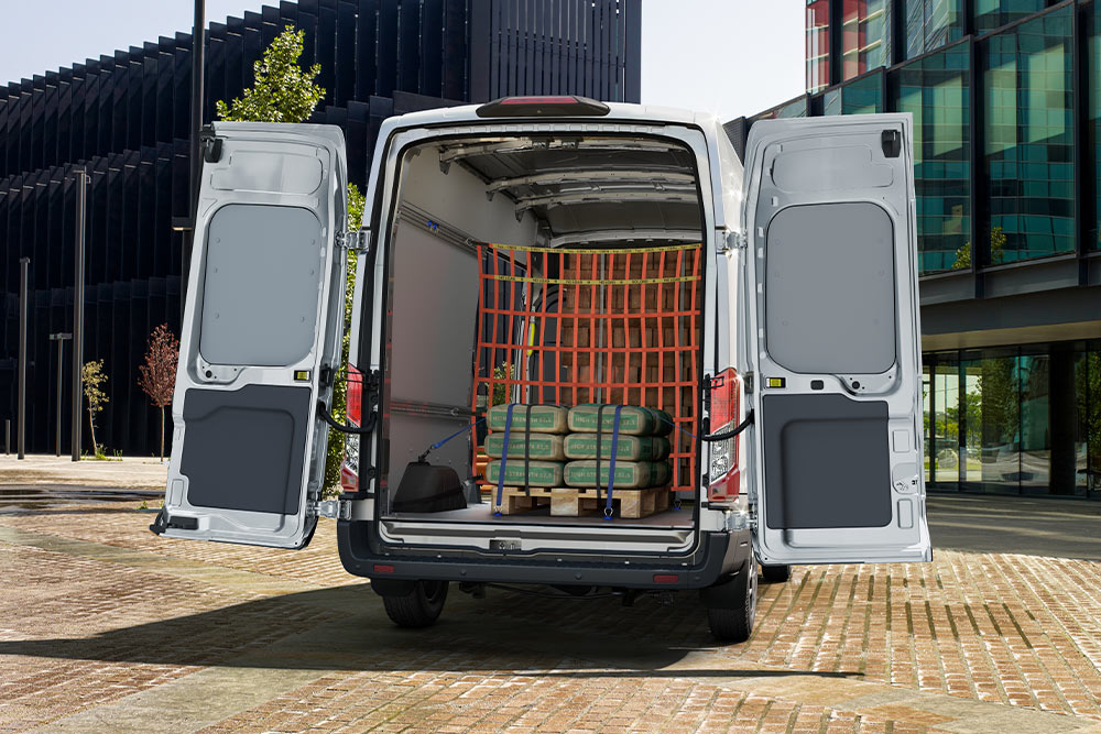 Ford Transit Doppelkabine mit geöffneten Hecktüren und Ladung im Laderaum.