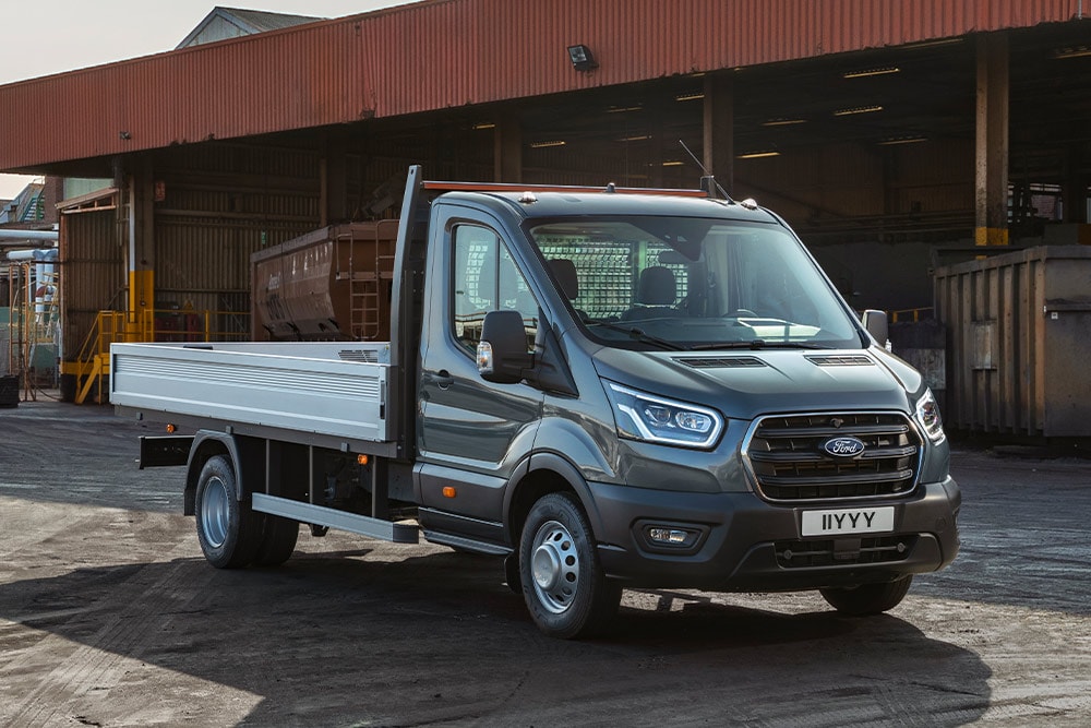 Ford Transit mit Fahrgestell und Fahrerhaus geparkt in einem Industriegebiet. 