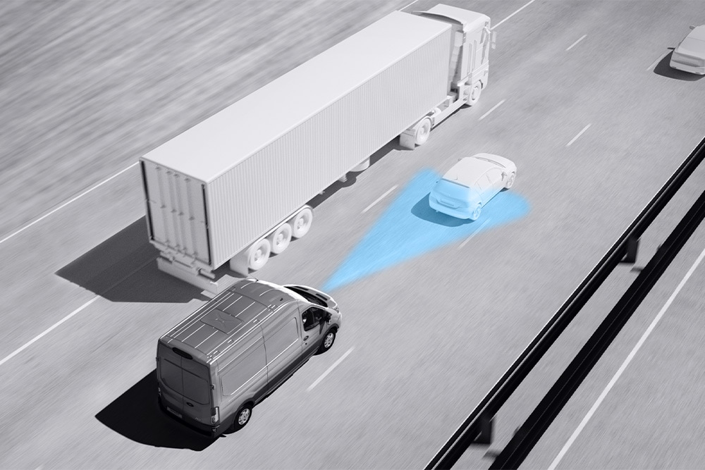 Graustufenzeichnung eines Ford Transit Van mit blauen Linien auf der Strasse, die die Verwendung fortschrittlicher Fahrerassistenzsysteme darstellt.