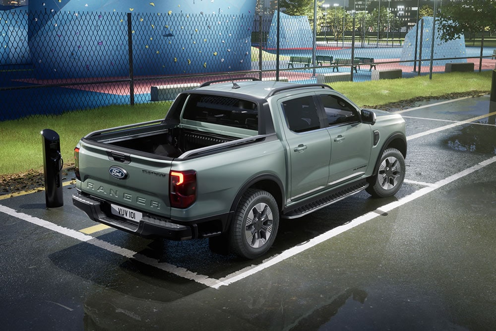 Ein grauer Ranger parkiert neben einem farbenfrohen Sportplatz mit Kletterwand.