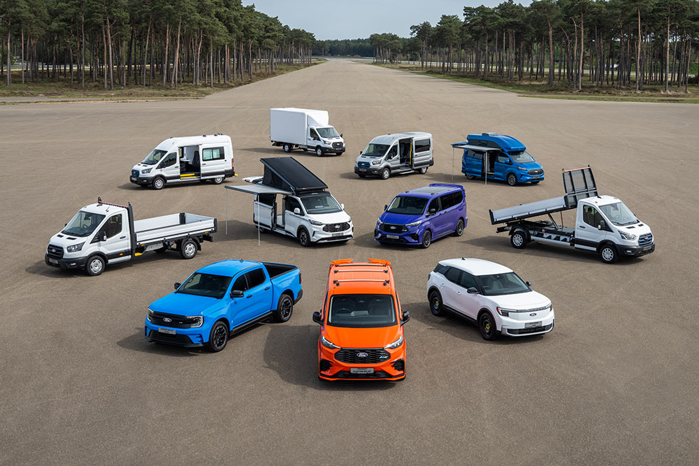 Eine Reihe von Ford Nutzfahrzeugen parkiert auf einem Prüfstrecken-Areal.