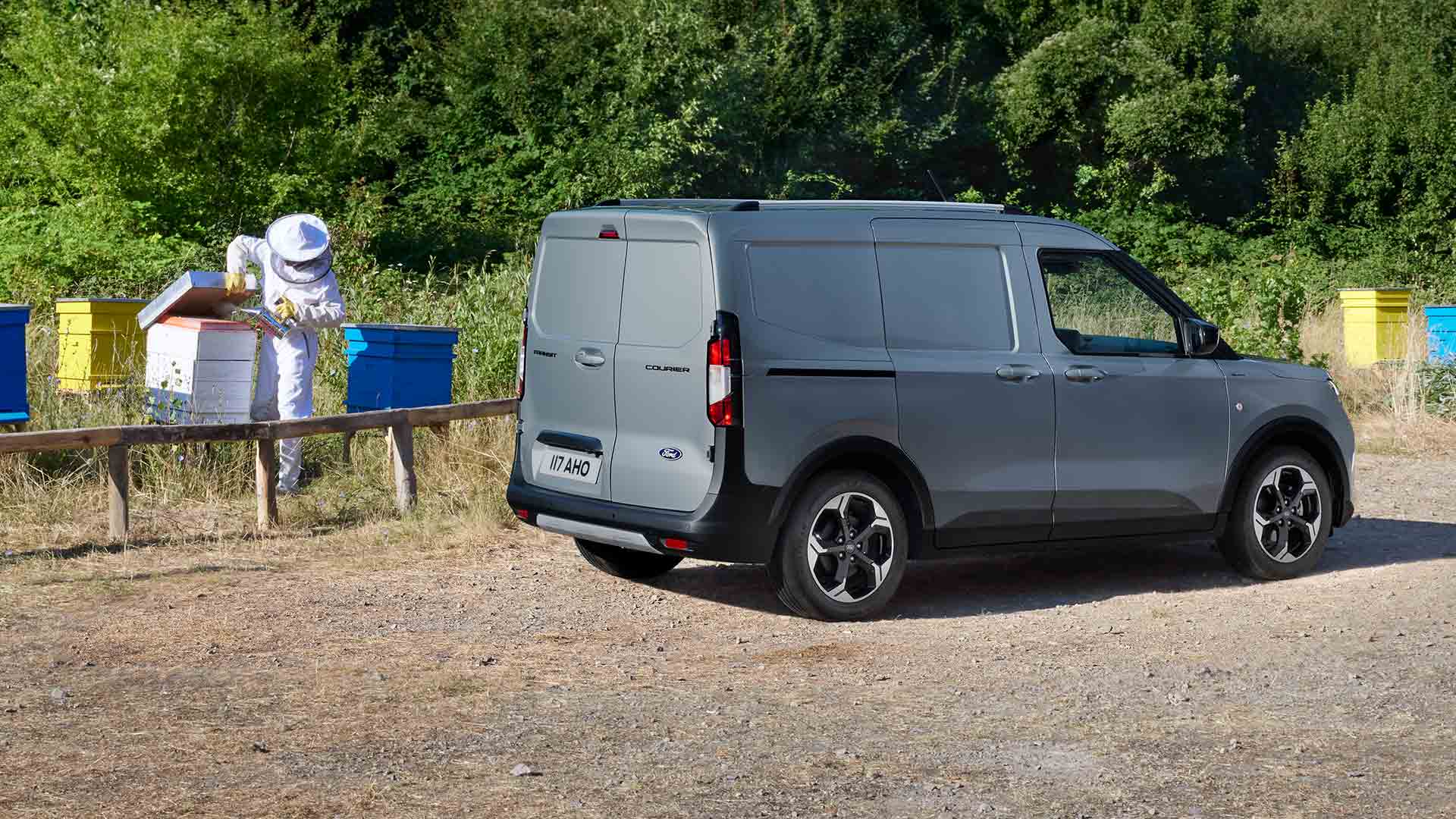 Imker arbeitet neben einem neuen Ford Transit Courier.