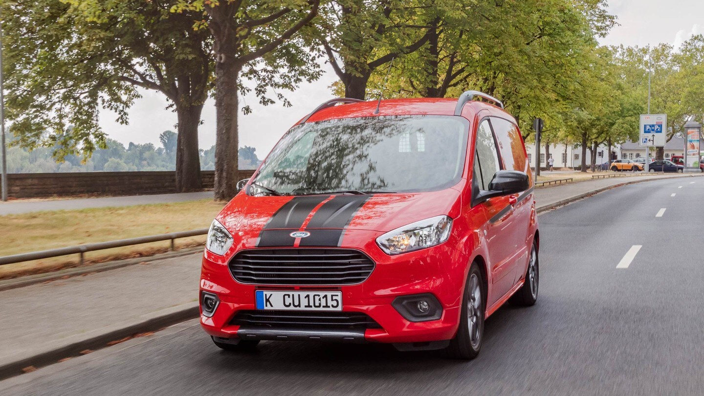 Red Ford Transit Courier Sport Van on city road