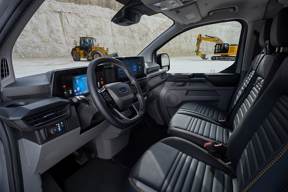 Innenansicht eines Ford Transit Custom Transporters mit Armaturenbrett, Lenkrad und Sitzen.