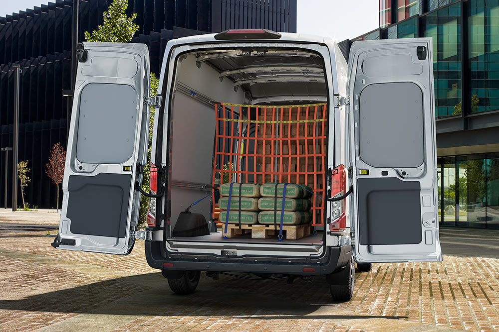 Eine Rückansicht des Innenraums eines weißen Ford-Transporters, der in der Nähe von Bürogebäuden geparkt ist.