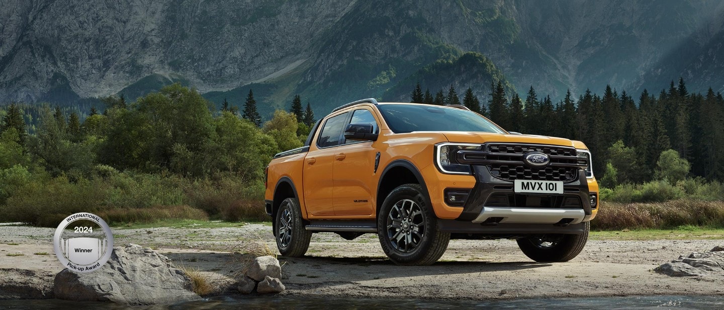 Orange Ford Ranger 3/4 front view on gravel in front of White Ford Ranger 3/4 rear view