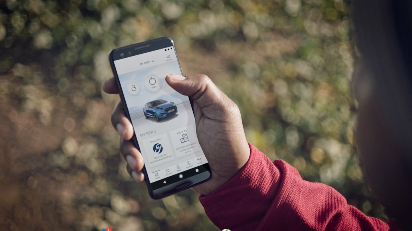 FordPass App auf einem Smartphone mit einem blauen Ford Puma ST auf dem Display