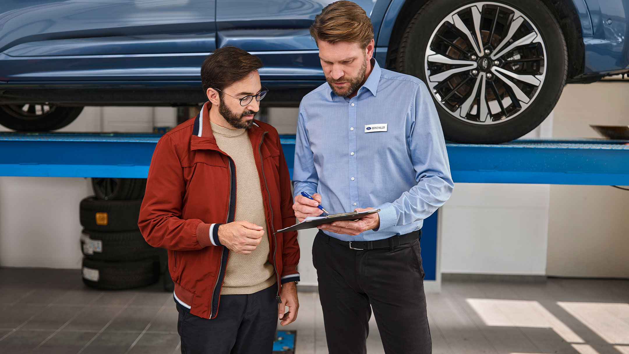 Un cliente parla con un esperto Ford Service nell’officina di un partner Ford.