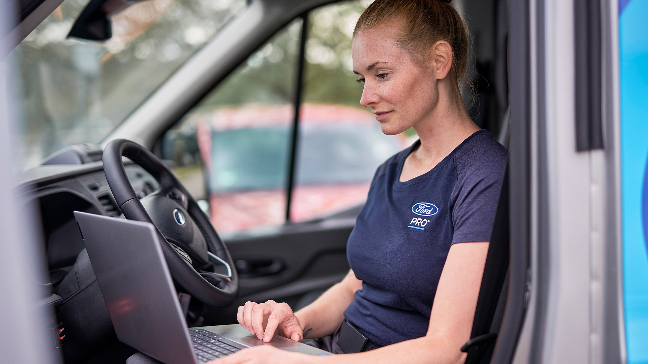 Un’esperta Ford Pro consulta il suo laptop durante il Ford Service.