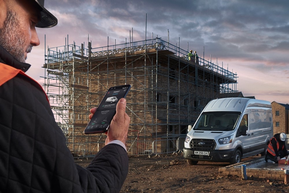 Bauarbeiter hält Smartphone in der Hand